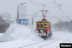 Трамвай расчищает пути после снегопада в Москве 13 февраля 2021 года. Фото: Reuters