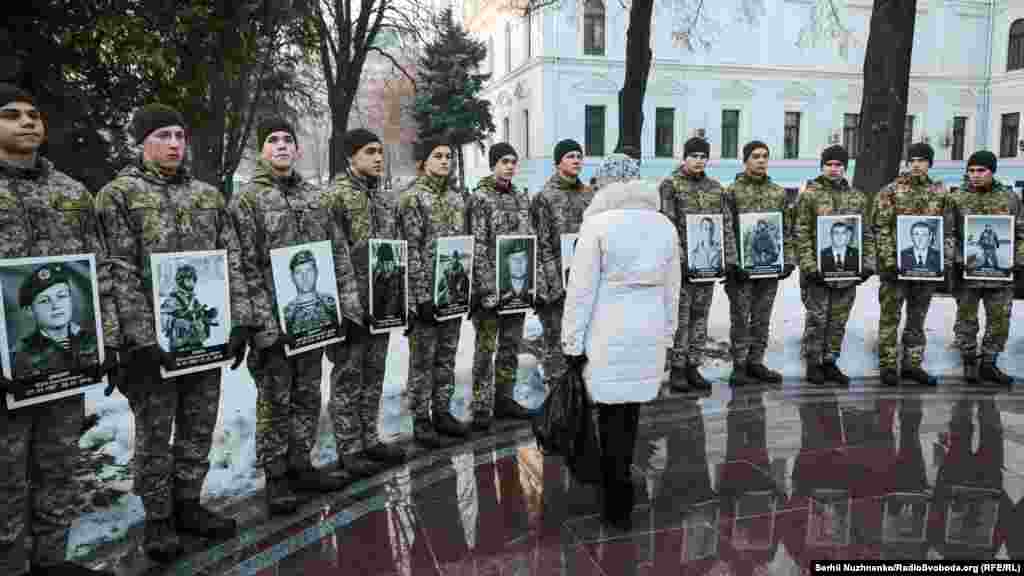 Женщина смотрит на портреты погибших защитников Донецкого аэропорта